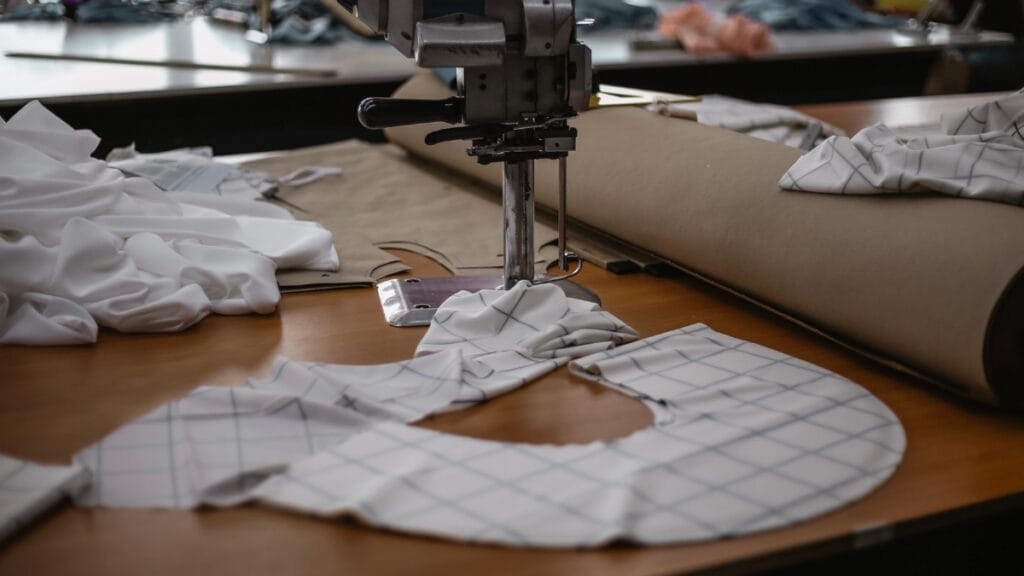 Sewing machine and fabric pieces on a table, showcasing the process of transforming textiles into fabric