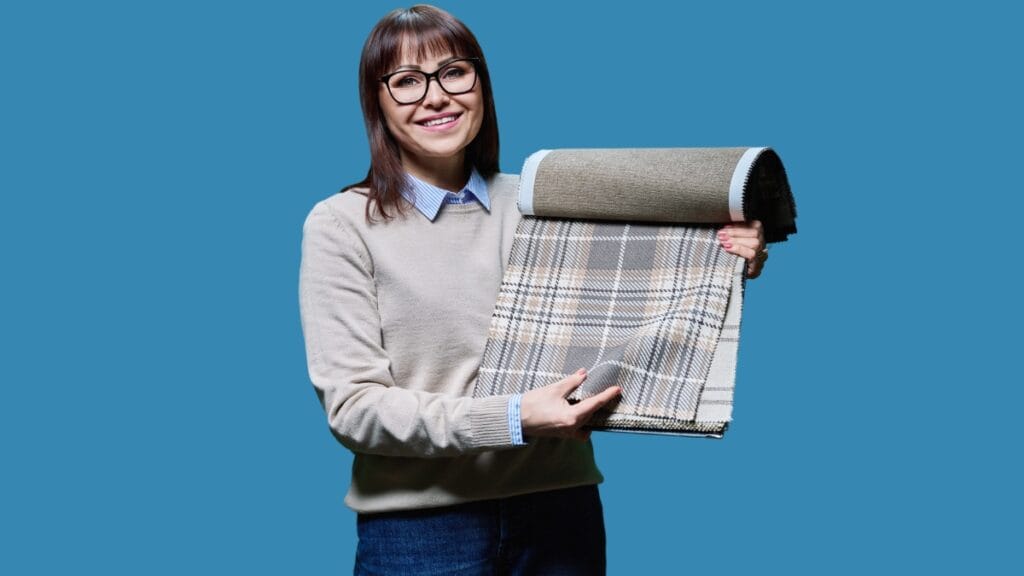 Woman holding a roll of upholstery fabric, showcasing its texture and color
