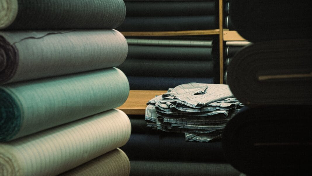 A collection of rolled fabric bolts in various colors showcasing different fabric textures