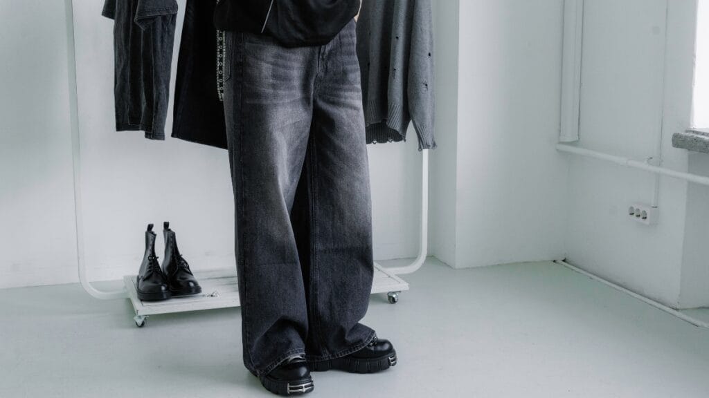 Person wearing stylish black baggy cargo jeans with chunky boots, showcasing modern streetwear fashion