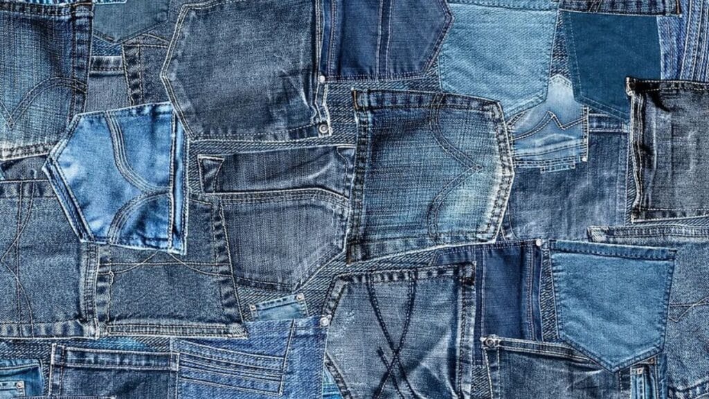 Macro shot of denim fabric showing diagonal weave and faded indigo color.
