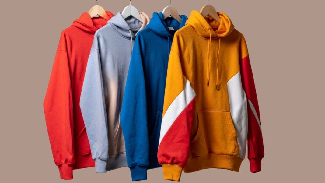 Collection of colorful hoodies hanging on a rack, showcasing a variety of vibrant colors
