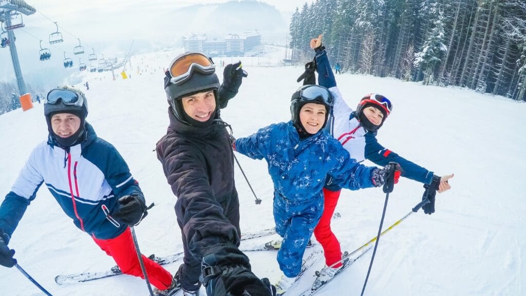 Friends skiing and posing in winter gear at a snowy ski resort.