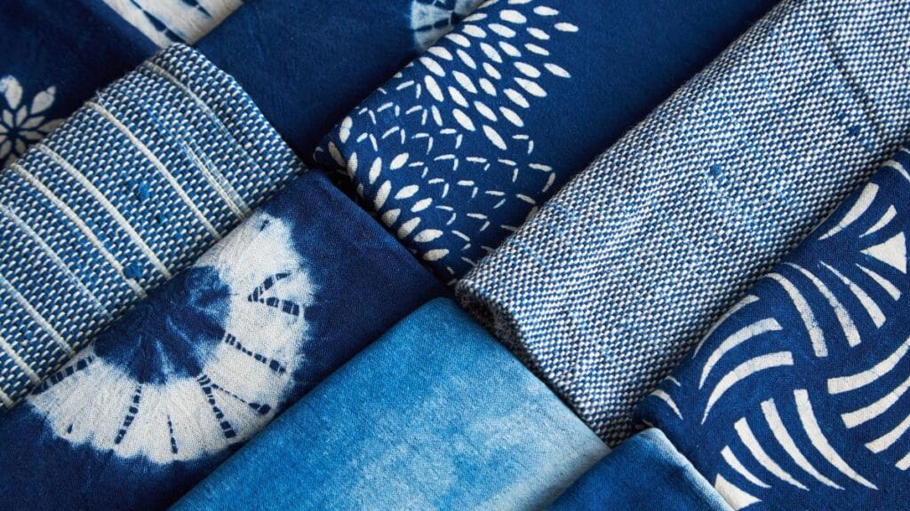 Assorted blue fabric swatches with different textures and patterns arranged in a grid layout