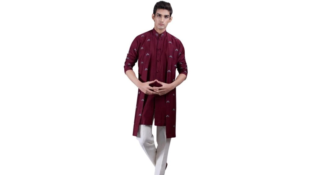 A full-length photo of a man wearing a maroon tunic shirt with small printed patterns and white pants, standing against a plain white background.
