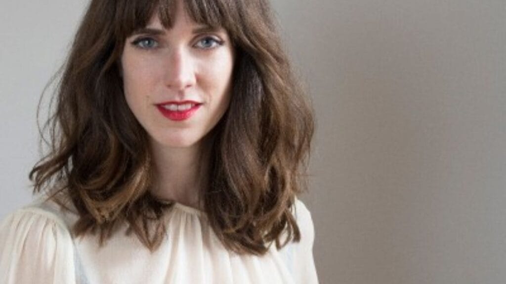 Woman wearing a light viscose blouse with soft texture, shown in a simple indoor setting.