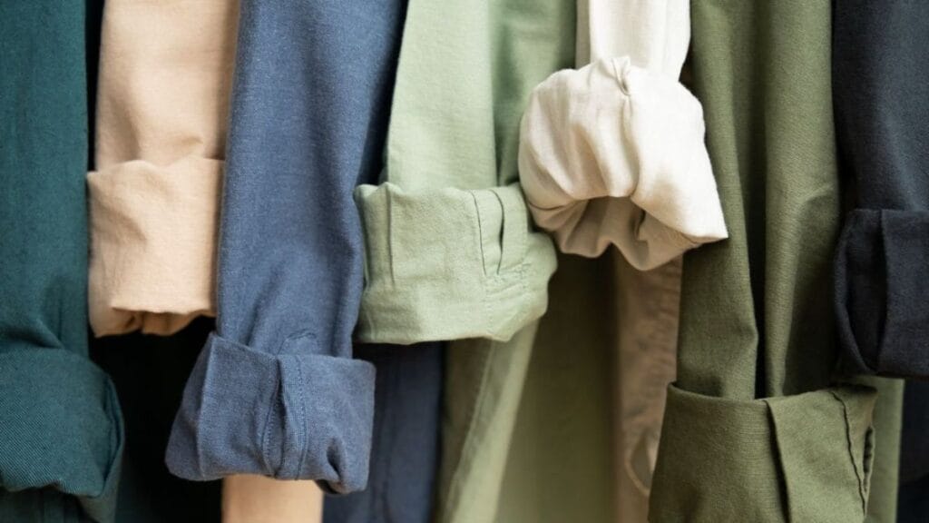 Close-up of rolled sleeve shirts in soft fabrics showing different colors and textures.
