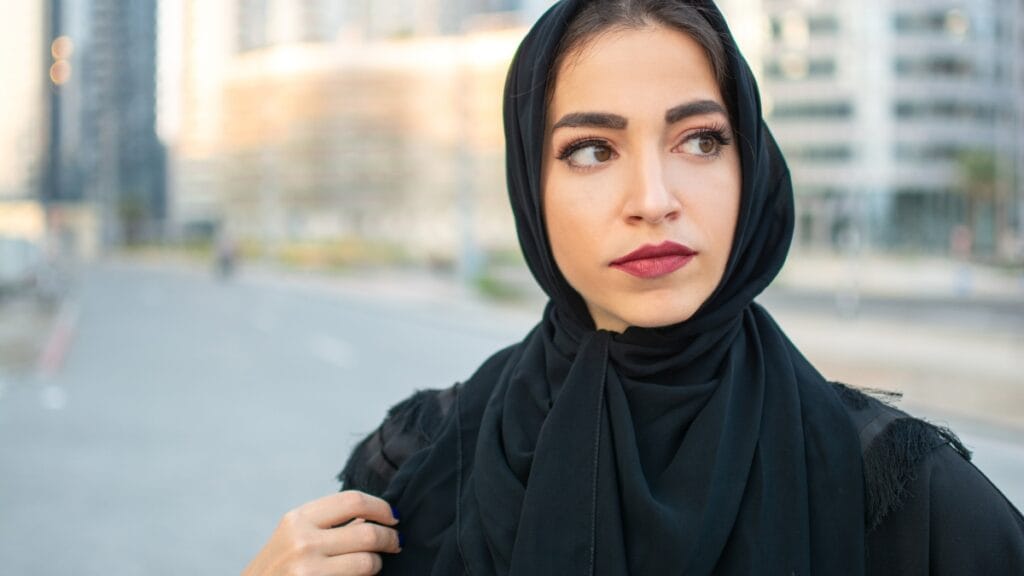 Woman wearing a modest abaya and hijab, standing gracefully with a calm and elegant appearance.
