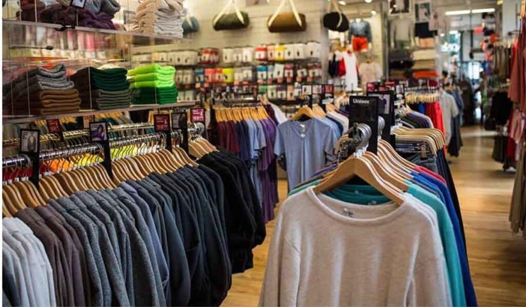 A well-organized garment factory retail outlet showcasing a variety of apparel on racks and shelves.