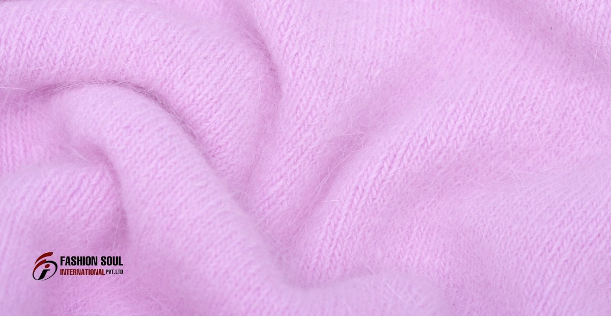 Close-up of soft, pink Angora wool fabric with a fluffy texture, featuring a subtle knit pattern.