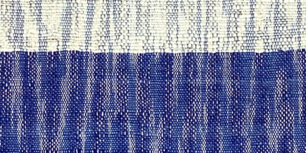 A beautifully woven Ikat fabric with vibrant colors and intricate patterns, showcasing the unique blurred effect of traditional dyeing techniques.