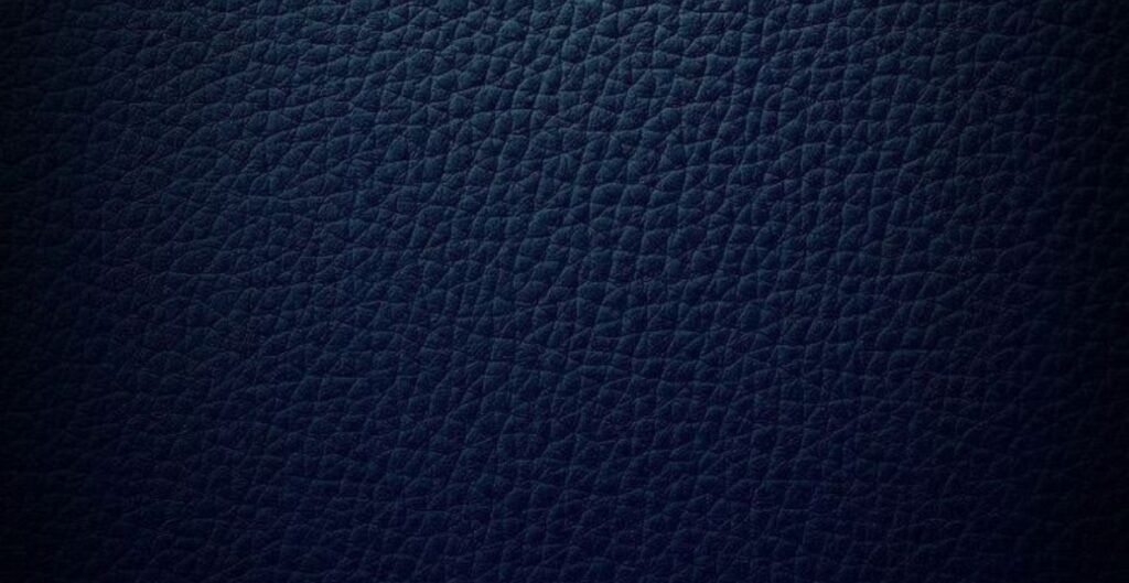 Close-up view of dark blue split leather texture, displaying a fine, crinkled pattern.