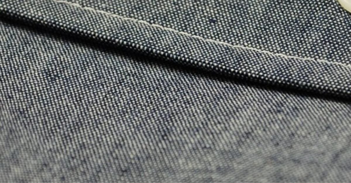 Close-up view of chambray fabric showing its fine weave, soft texture, and signature blue and white color contrast.