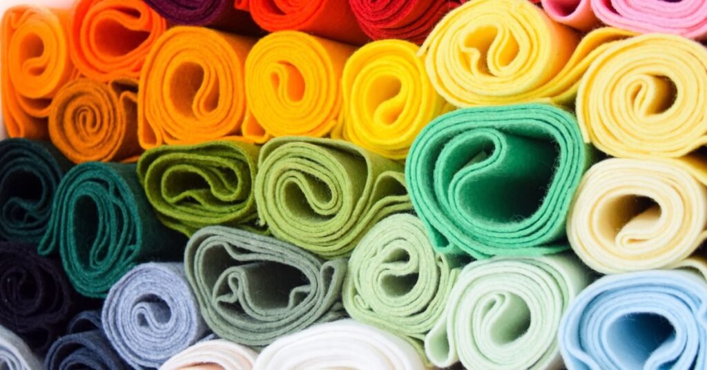 Colorful rolled felt fabric pieces arranged in a neat pattern, showcasing soft texture and vibrant hues.