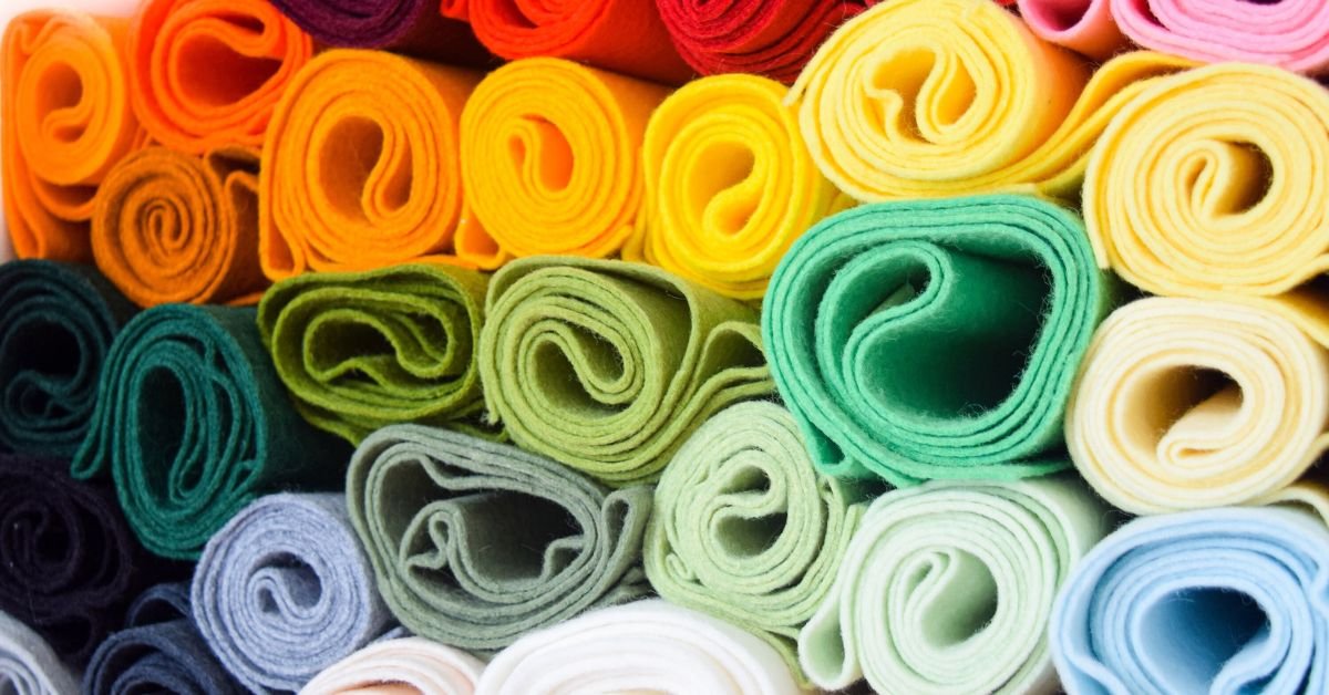 Colorful rolled felt fabric pieces arranged in a neat pattern, showcasing soft texture and vibrant hues.