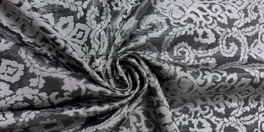 A close-up of luxurious damask fabric showcasing its intricate woven patterns and elegant sheen.