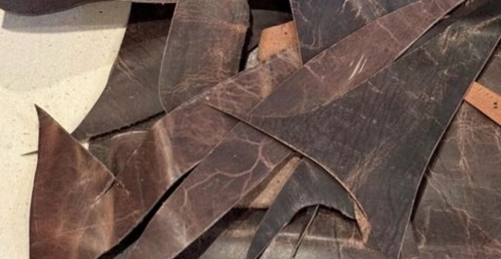 Close-up of various scraps of recycled leather in shades of brown and black.