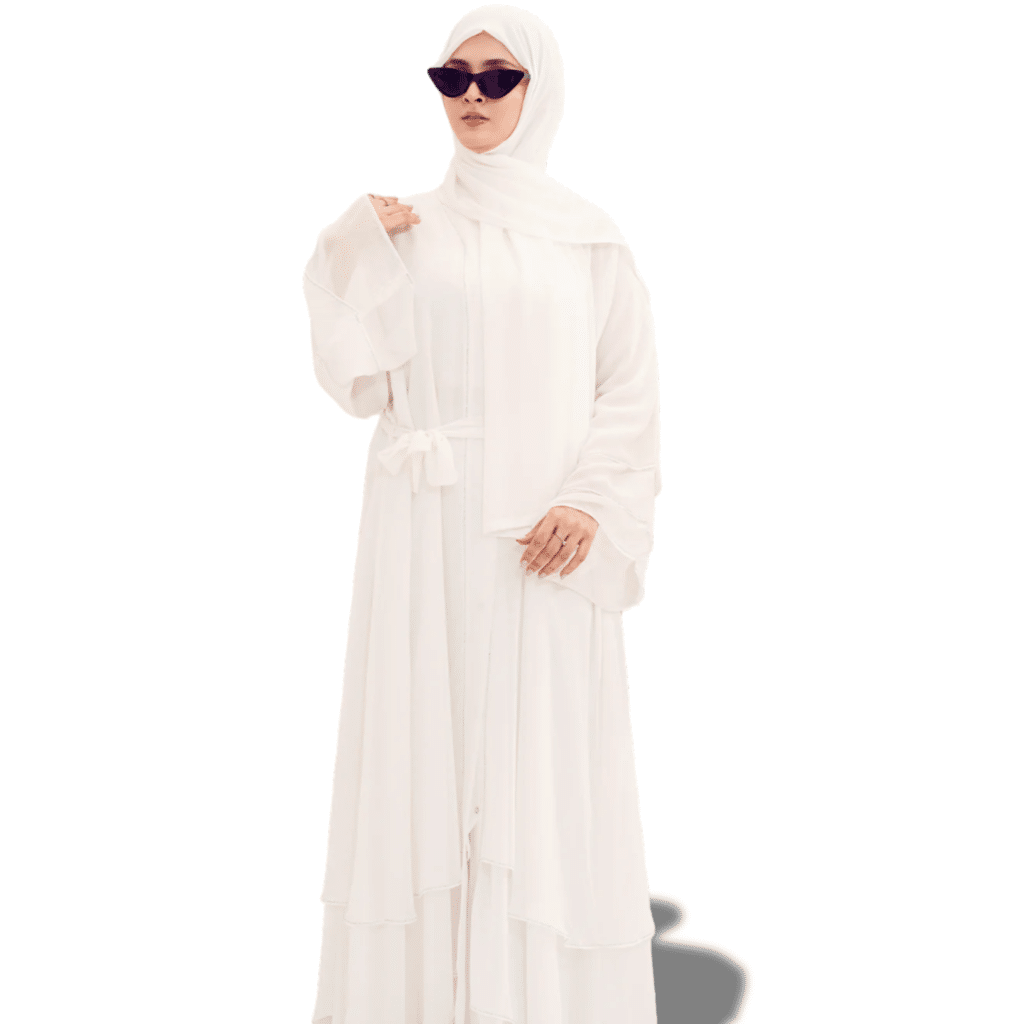 Woman in a flowing white abaya with hijab and sunglasses