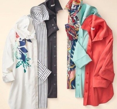 A selection of women's shirts in various colors and patterns, displayed neatly.