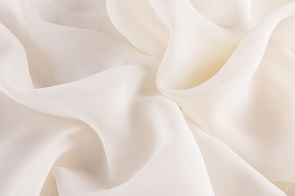 Close-up of a delicate, flowing chiffon fabric in a soft cream color. remove wrinkles from chiffon