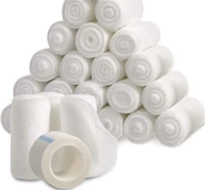 A stack of rolled cotton bandages and gauze, with some loosely arranged in the foreground.