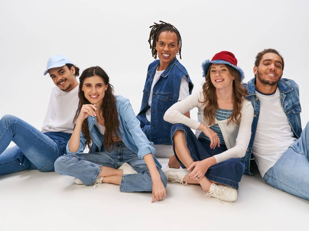 Diverse group of five young adults posing in stylish denim outfits.