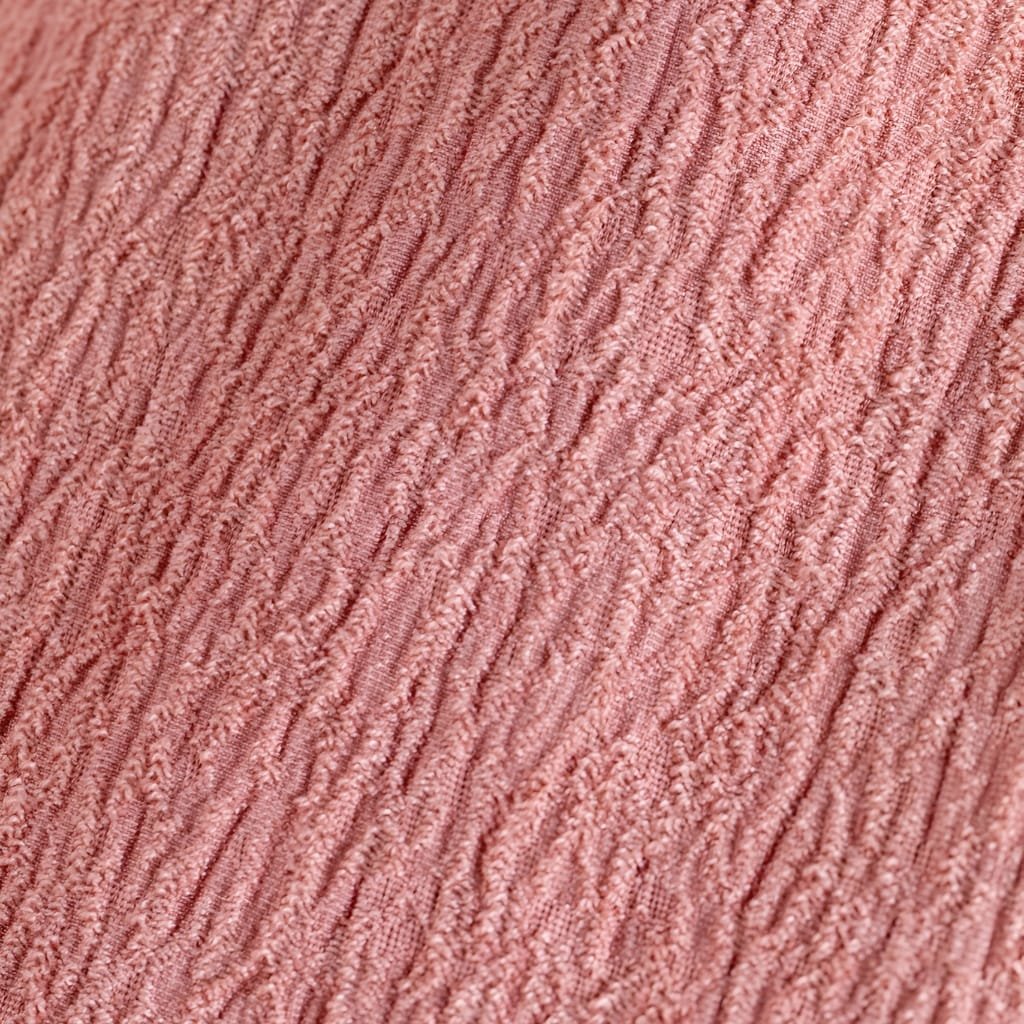 A close-up image of a textured fabric in a soft pink color, showing detailed thread patterns and a ribbed surface.