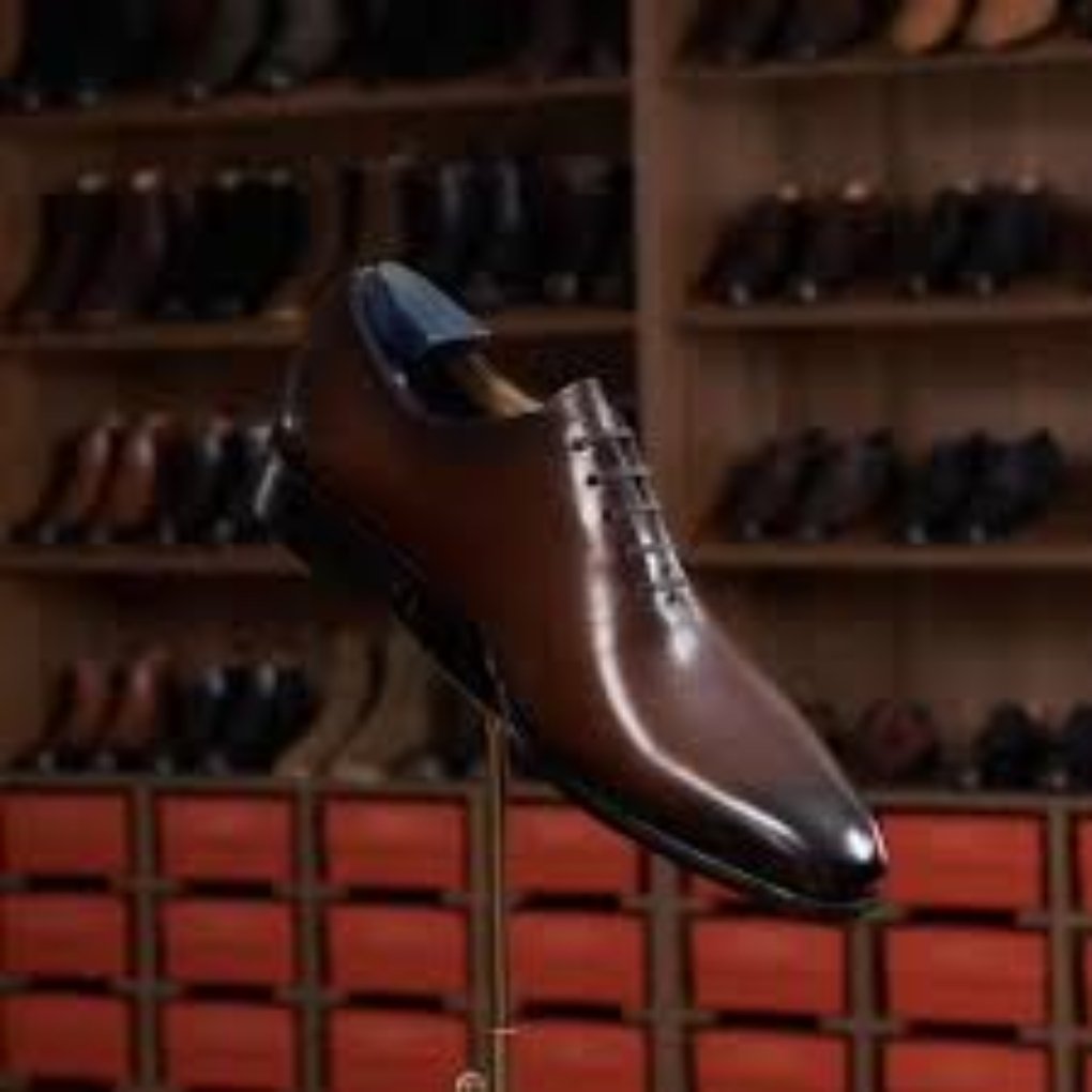 Various pieces of cowhide leather in different colors shoes and textures hanging in a display.