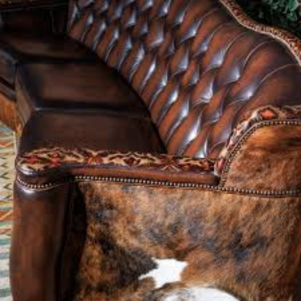 Various pieces of cowhide leather in different colors and textures hanging in a display.
