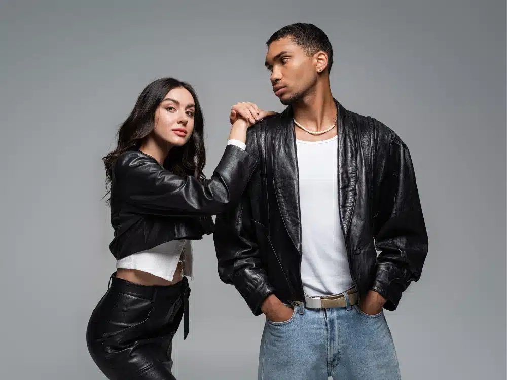 Stylish couple posing in matching black leather jackets.