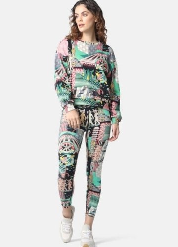 A model poses in vibrant, patterned leggings and a matching sweatshirt from Terez, showcasing a mix of colors and designs.