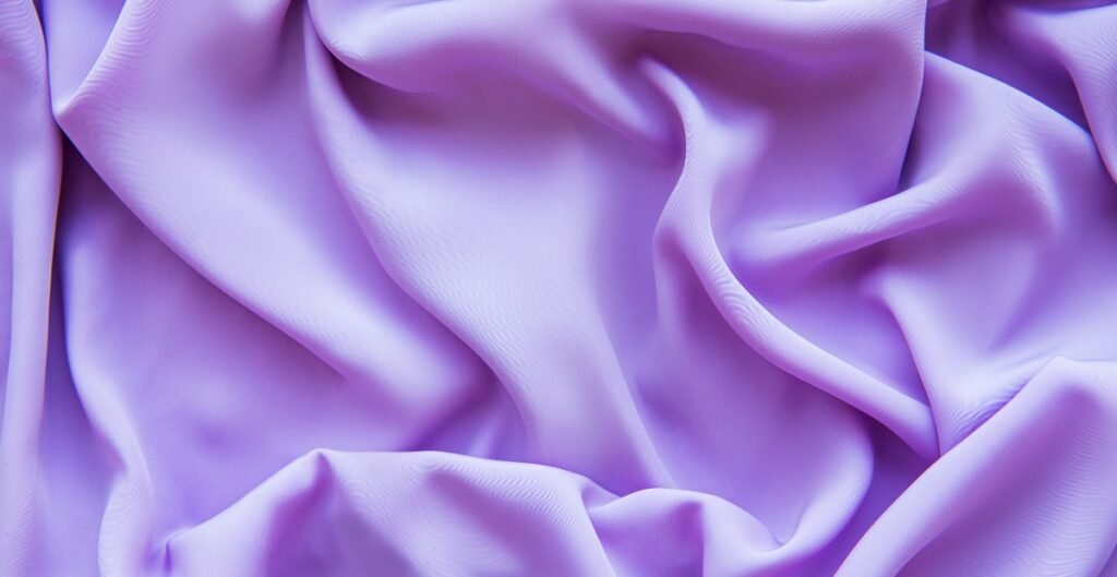 Close-up of lavender chiffon fabric with soft wrinkles and a smooth texture.