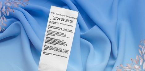 Care instructions for rayon fabric displayed on a white tag against a light blue rayon fabric.