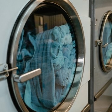 A close-up view of wrinkled rayon fabric inside a commercial dryer. " remove wrinkles from rayon