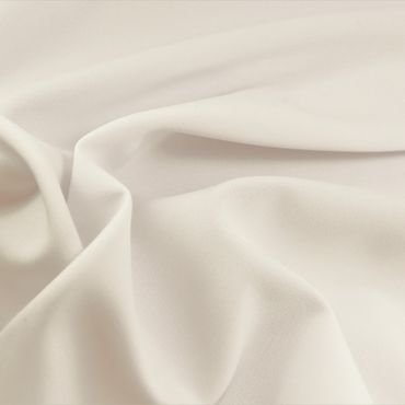 A close-up image of soft, luxurious light cream rayon fabric, displaying its smooth texture and drape. " rayon fabric shrink"