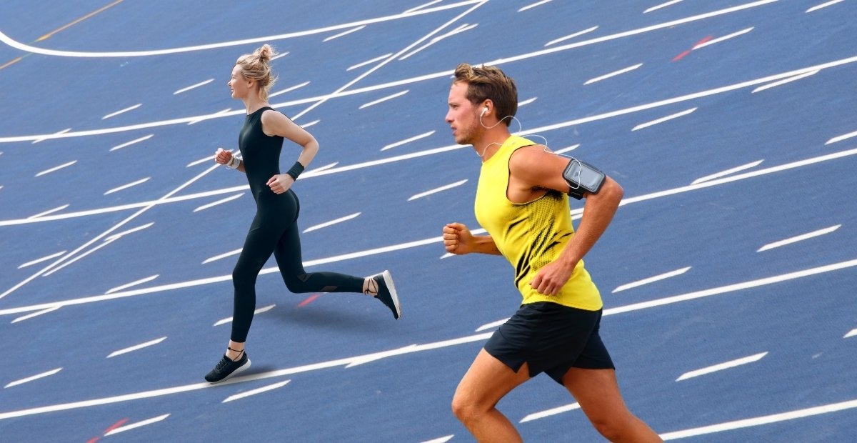 A woman and a man running on a track. The woman wears a black athletic outfit, while the man is in a bright yellow tank top and black shorts. Both are wearing running shoes. top sportswear