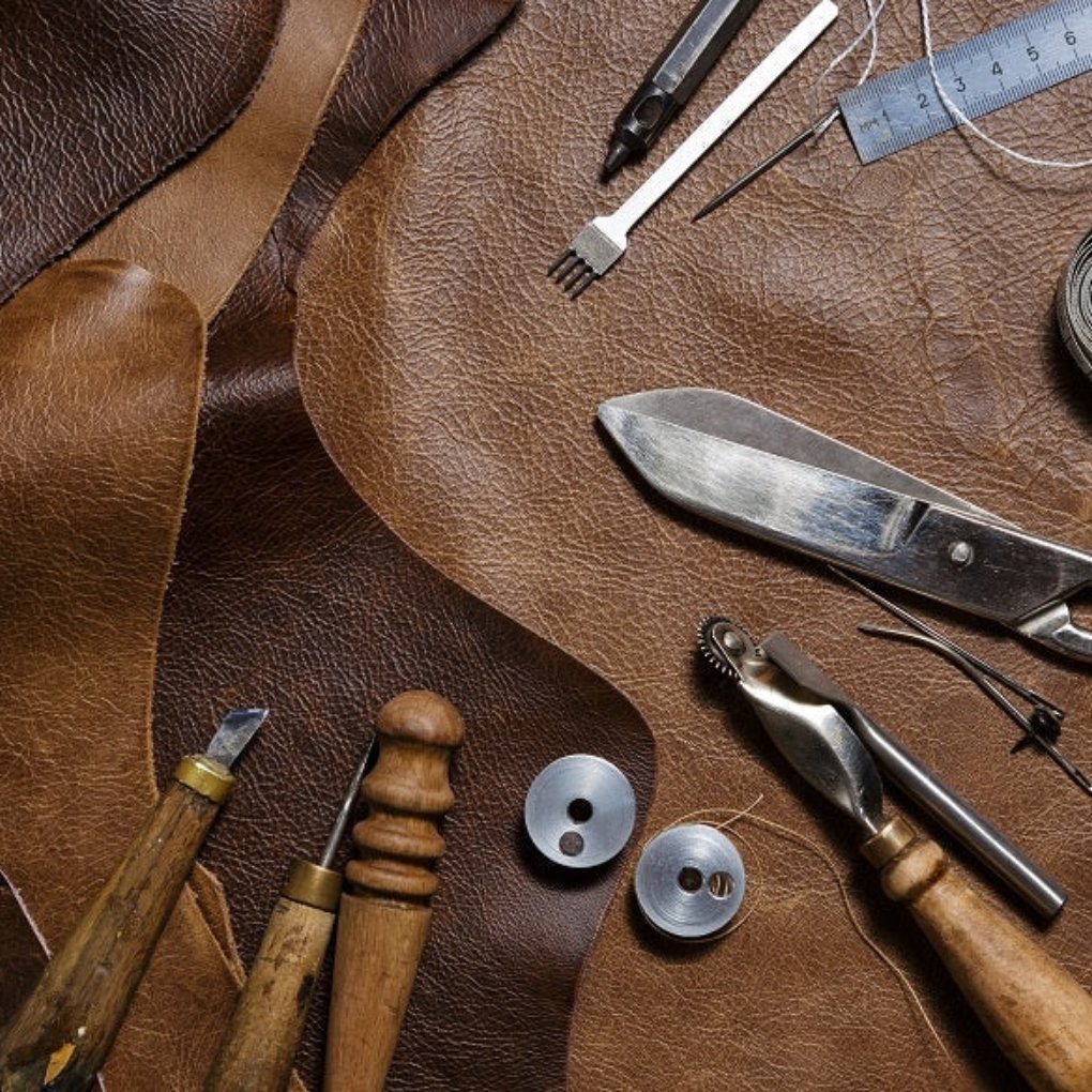 Various pieces of leather in different colors and textures hanging in a display.
