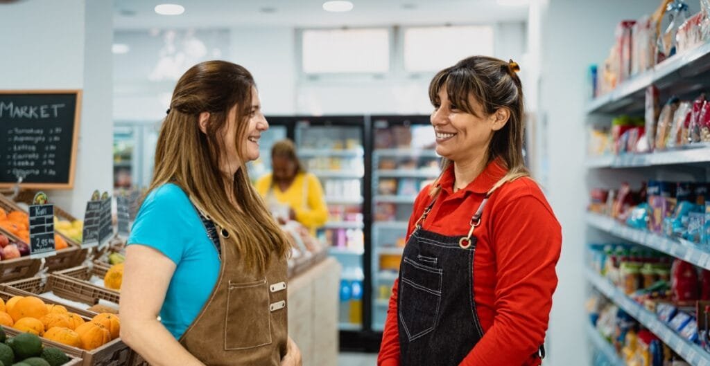 "Friendly shop staff assisting a customer with fabric recommendations at a local sewing store"