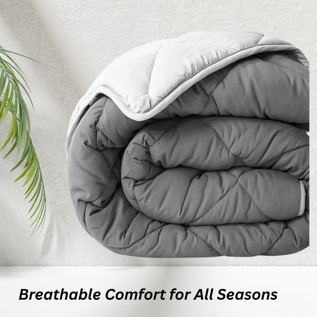 A neatly folded gray and white quilt or comforter resting on a white surface next to a green plant, with the caption "Breathable Comfort for All Seasons" beneath.