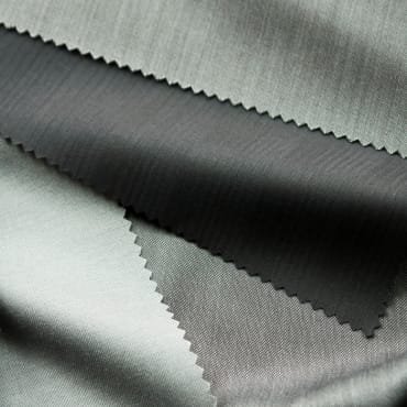 Close-up image of a variety of fabric swatches with intricate patterns and textures, highlighting the customizable and design-friendly nature of polyester knit fabric.