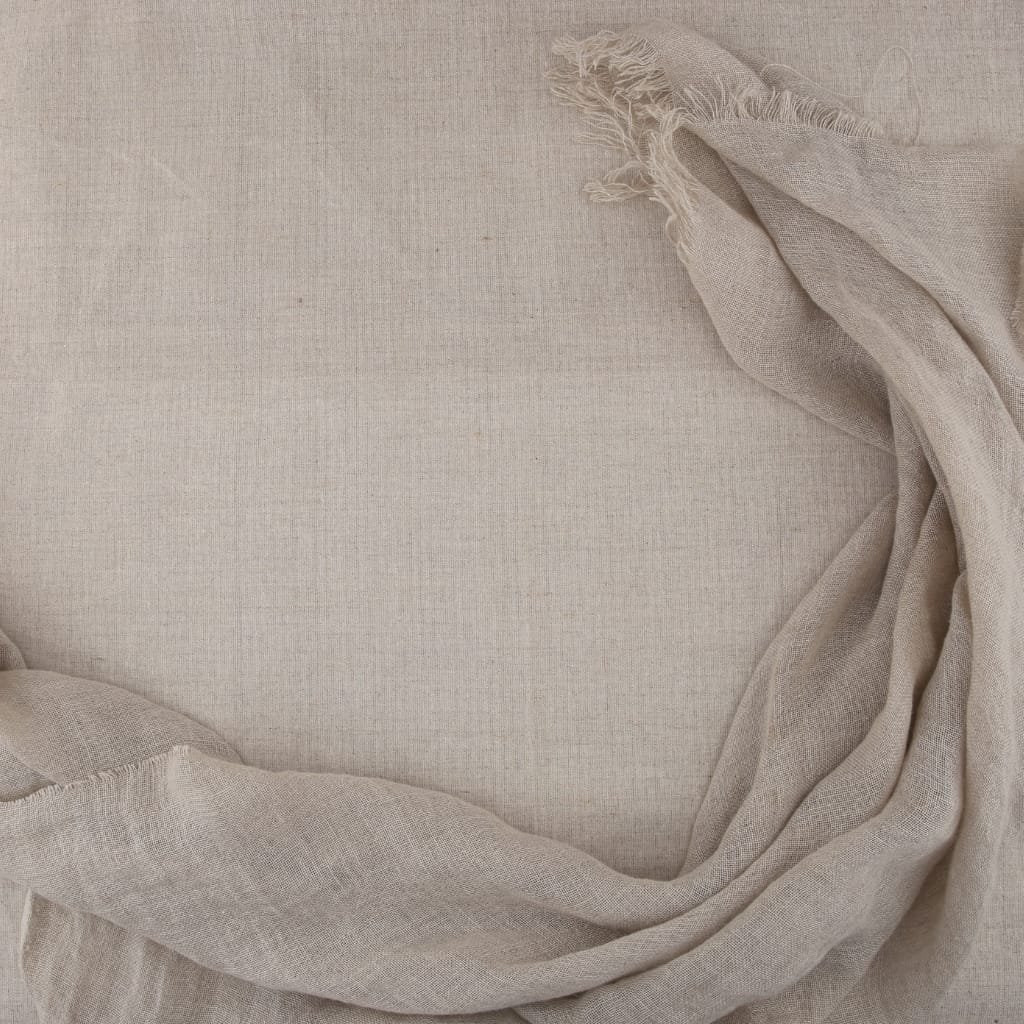 A flat, textured beige linen fabric with loosely draped, slightly frayed edges on the top and bottom, creating a soft, elegant background.