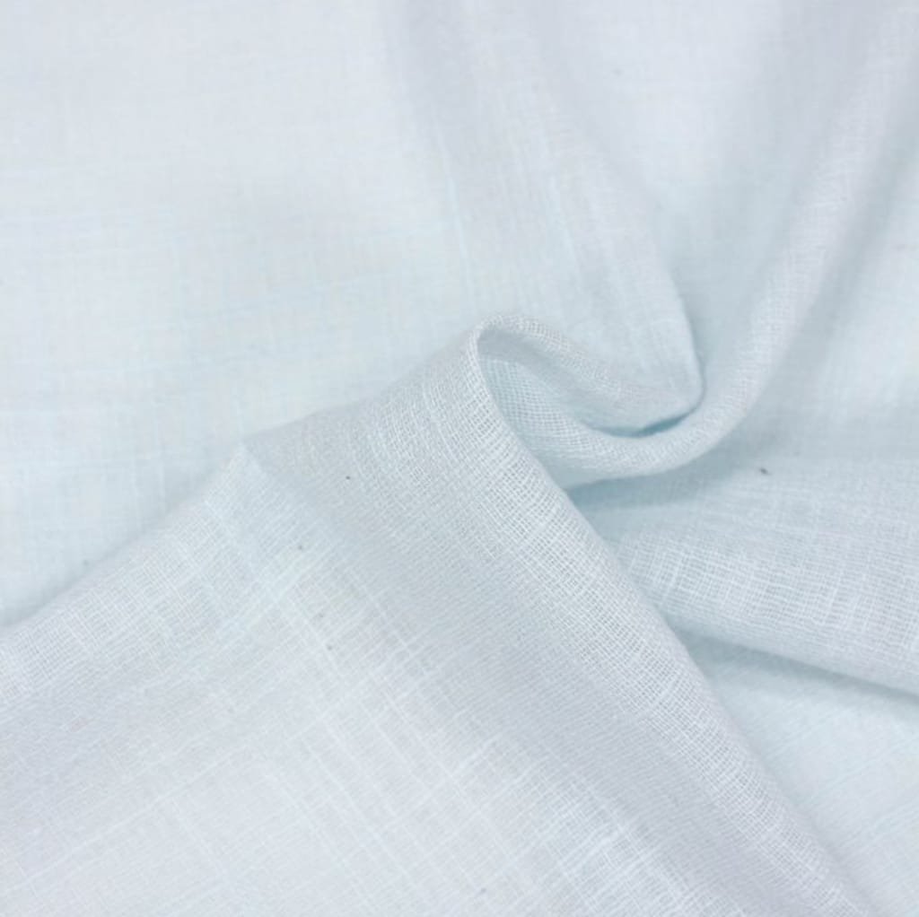 Close-up image of light-colored, semi-sheer cotton voile fabric with a soft, smooth, and slightly textured surface, gently folded to show its lightweight and airy quality.