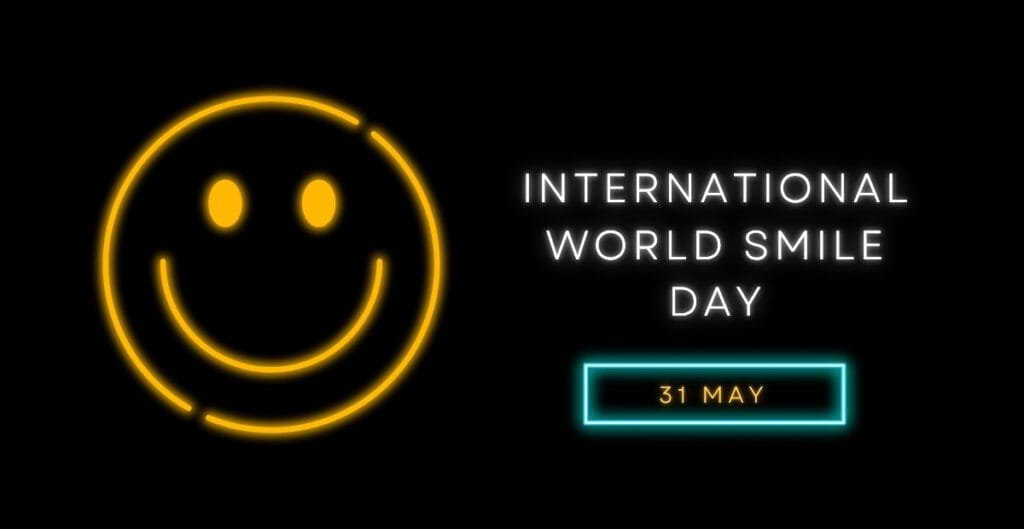 Neon smiley face with the words “International World Smile Day – 31 May” on a black background.