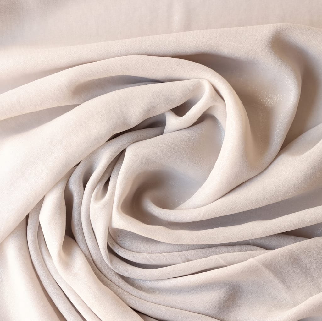  Close-up image of soft, cream-colored Pima cotton fabric arranged in gentle folds.