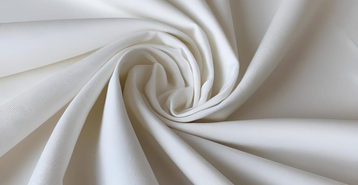 Close-up of smooth, white cotton fabric in a spiral shape.