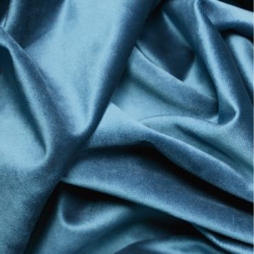 Close-up image of a smooth, shiny, blue polyester knit fabric with visible folds and slight texture.