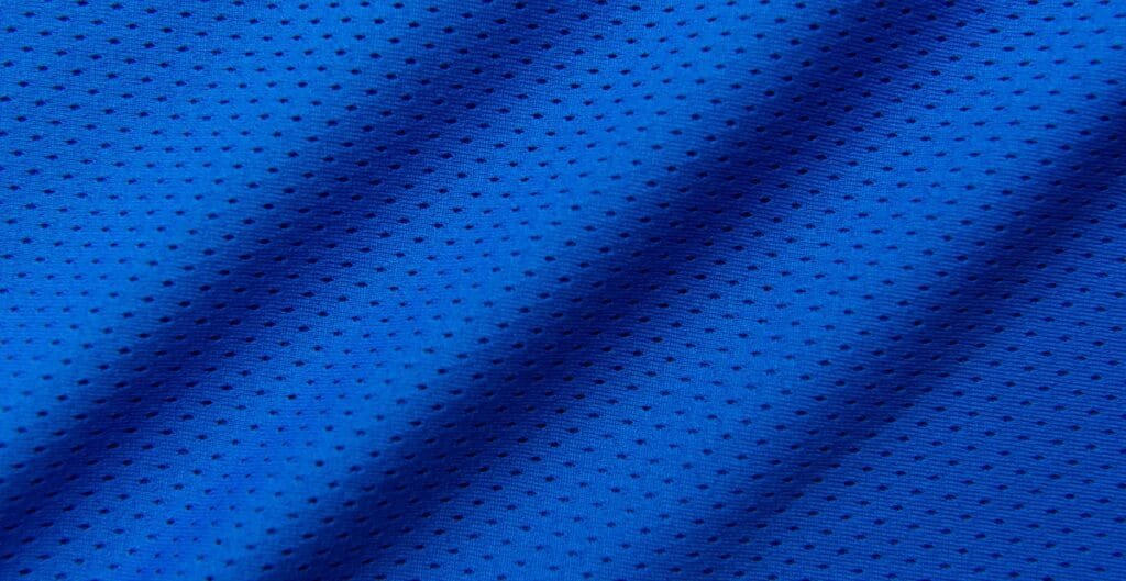Close-up image of a bright blue polyester mesh fabric with small, evenly spaced holes.
