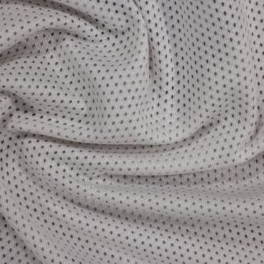 Close-up of soft, light-colored polyester mesh fabric with small, evenly spaced black dots.