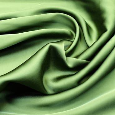 Close-up image of smooth, shiny green polyester fabric with soft folds.