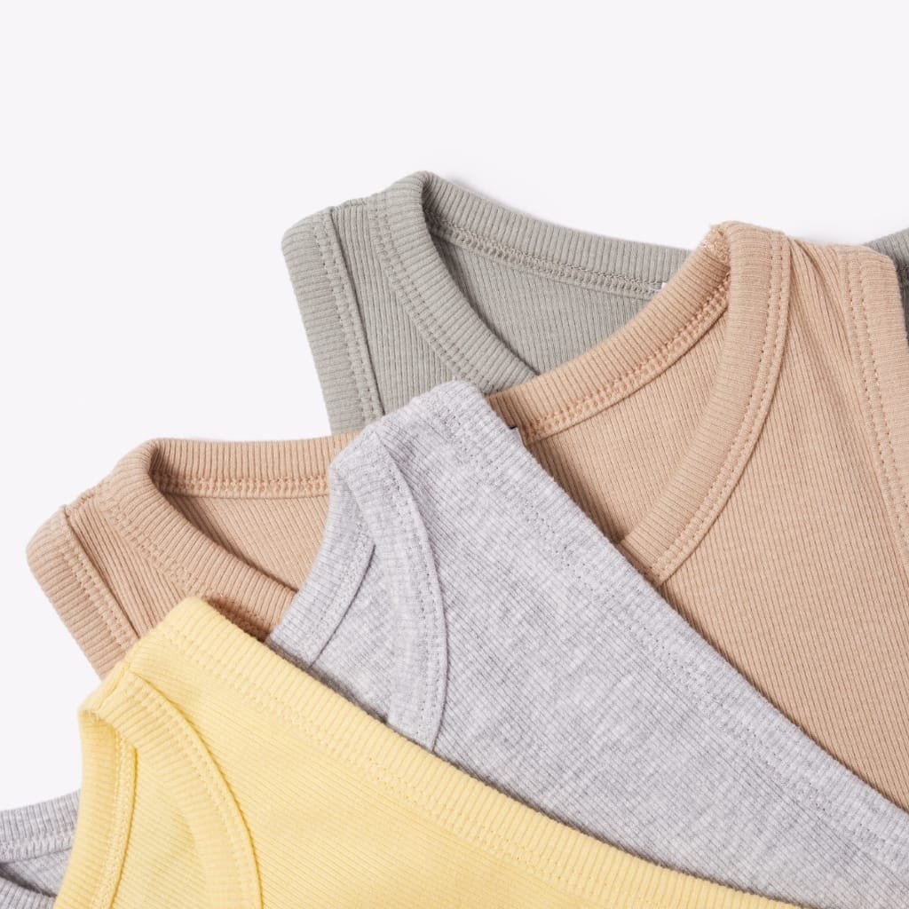 Stacked pastel-colored ribbed-knit sweaters arranged neatly against a white background.